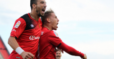 Brandon y Díaz celebrando el hattrick del santanyiner ante el Huesca. Foto: Fútbol Balear.